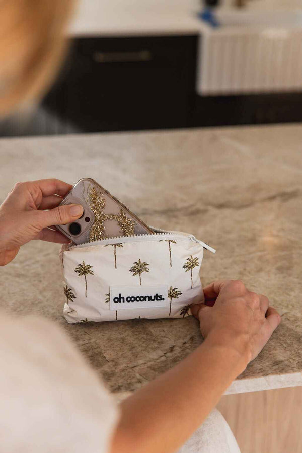 model holding oh coconuts pouch with sparkly iphone case 