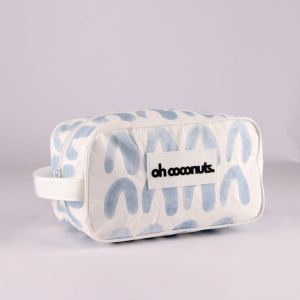 Holding handle blue arch cosmetic bag and palm tree zip. 