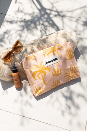 Pink palms with beach towel by pool with water resistant material. 