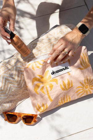 Large pink palms beach pouch or clutch holding sunglasses and essentials. 