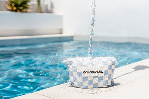 Water pouring onto water resistant beach pouch and repelling off material 