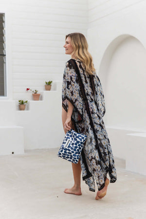 model wearing kimono with blue and white oh coconuts beach pouch