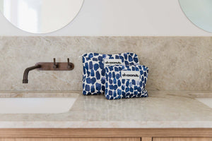 Two blue patterned bags with 'oh coconut!' branding on a bathroom counter.