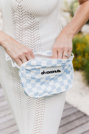 Person holding a blue and white checkered bag with 'oh coconuts' branding.