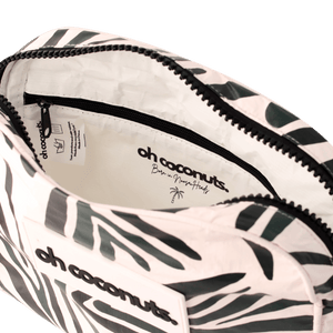 Fanny pack with palm leaf pattern and 'oh coconuts' branding on a black background